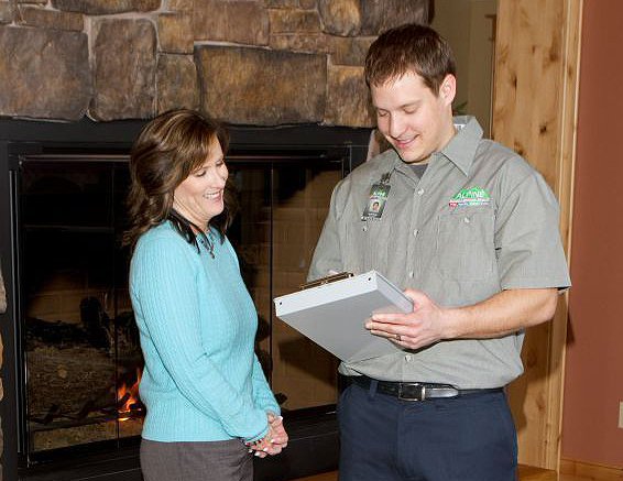 Alpine Cleaning & Restoration team member next to lady in front of fire place - representing Exceptional Customer Service